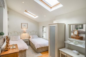 A bedroom with two beds, a desk, a mirror, and a wardrobe. - 2 Beacon High, Lindale (Grange-Over-Sands)