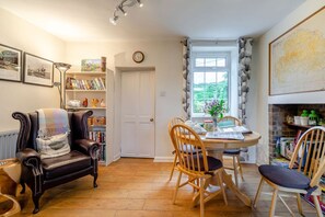 Ein gemütliches Wohnzimmer mit Kamin, Essbereich und Bücherregal.