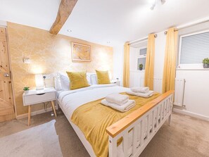 A bedroom with a bed, bedside tables, a nightstand, a window with curtains, and a radiator. - Lakeland View, Keswick Cumbria (Keswick)