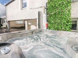 A hot tub with a control panel, a white building, and a green ivy-covered wall. - Lakeland View, Keswick Cumbria (Keswick)