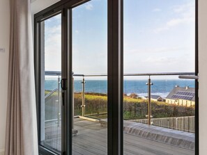Ein Balkon mit Blick auf das Meer und Häuser.