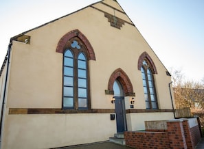A building with a triangular roof, two arched windows, and a door. - Moorsholm View, Lingdale (Saltburn-by-the-Sea)