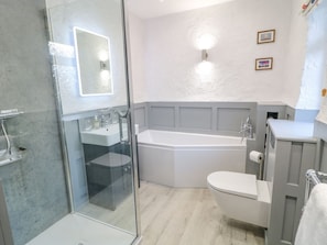 Un bagno moderno con box doccia in vetro, vasca freestanding e toilette.