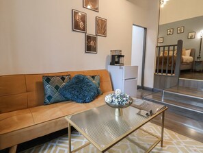 Un salon moderne avec un canapé, une machine à café et des objets de décoration.