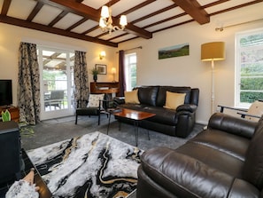 A living room with a sofa, coffee table, and a patterned rug.