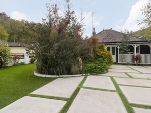 A residential property with a paved driveway, a covered porch, and a well-maintained lawn. - By The Beach, Seaton, Cornwall (Torpoint)