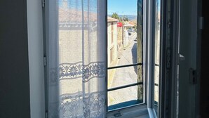 A room with a large window, a view of a street, and a door. - Charming 1-bedroom house in Azille perfect for a relaxing getaway (Azille)