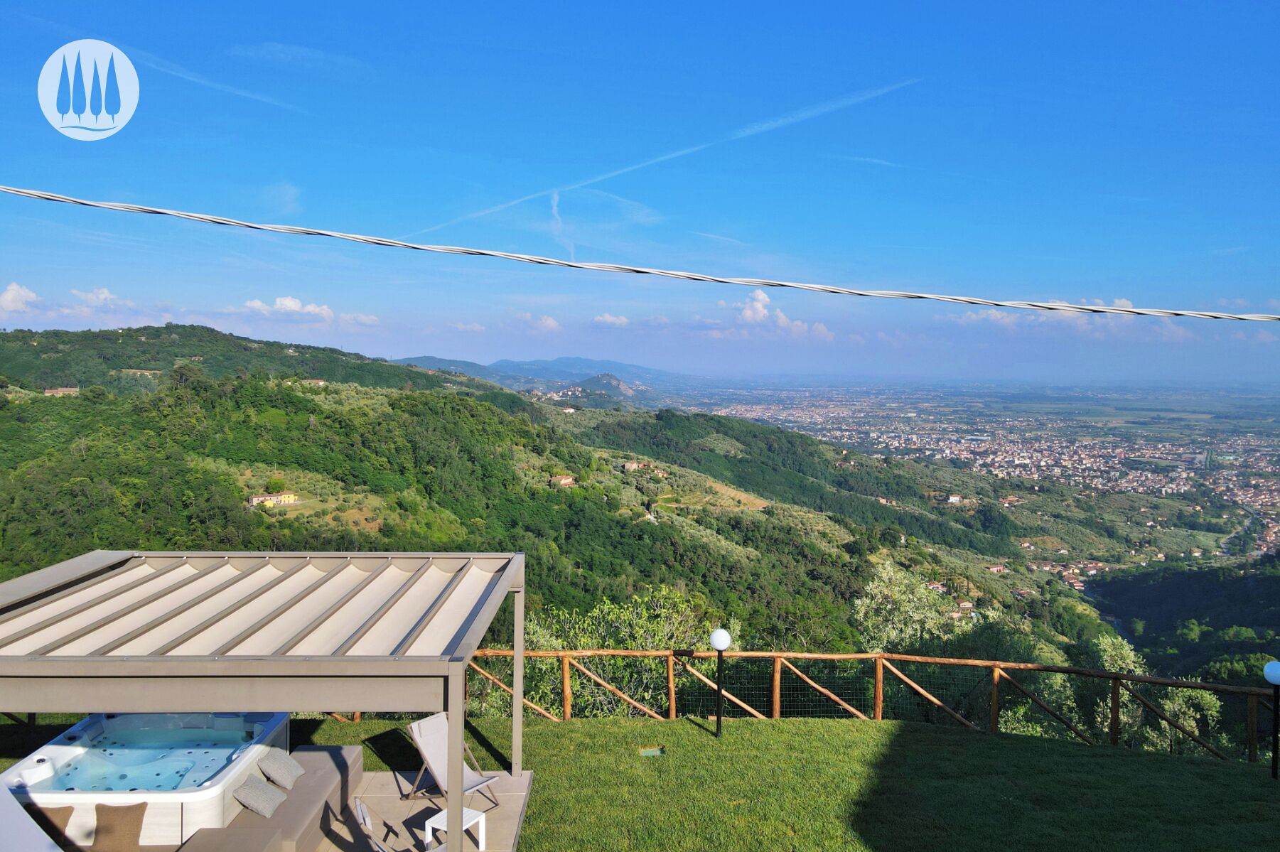 A terrace with a view of a city and hills.