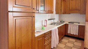 Una cocina con armarios de madera, piso a cuadros y un lavamanos.