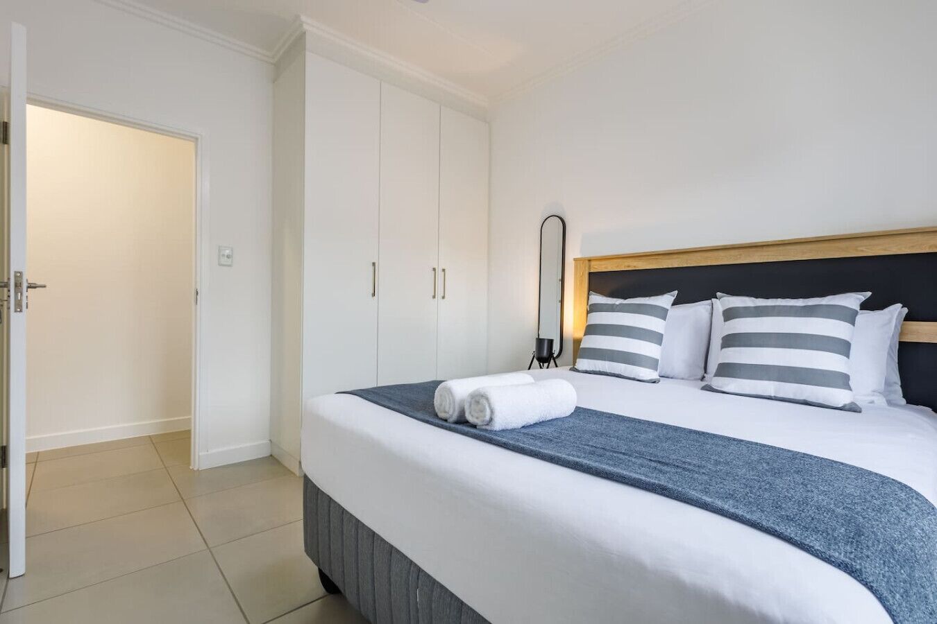Una habitación de hotel con cama, armario y puerta.