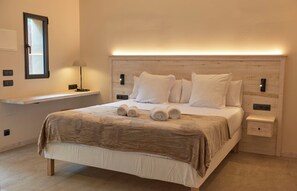 A bedroom with a bed, bedside tables, a nightstand, a lamp, and a mirror. - Studio Suite with private patio in Aiguablava-Begur (CT)