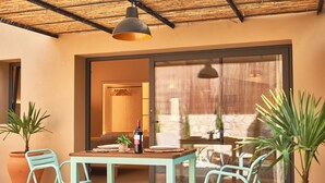 A patio with a table, chairs, potted plants, and a bottle of wine. - Studio Suite with private patio in Aiguablava-Begur (CT)