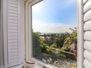 A window with a view of a garden and a distant landscape. - 1 Gibraltar Terrace, Aberfyfi. (Aberdovey)