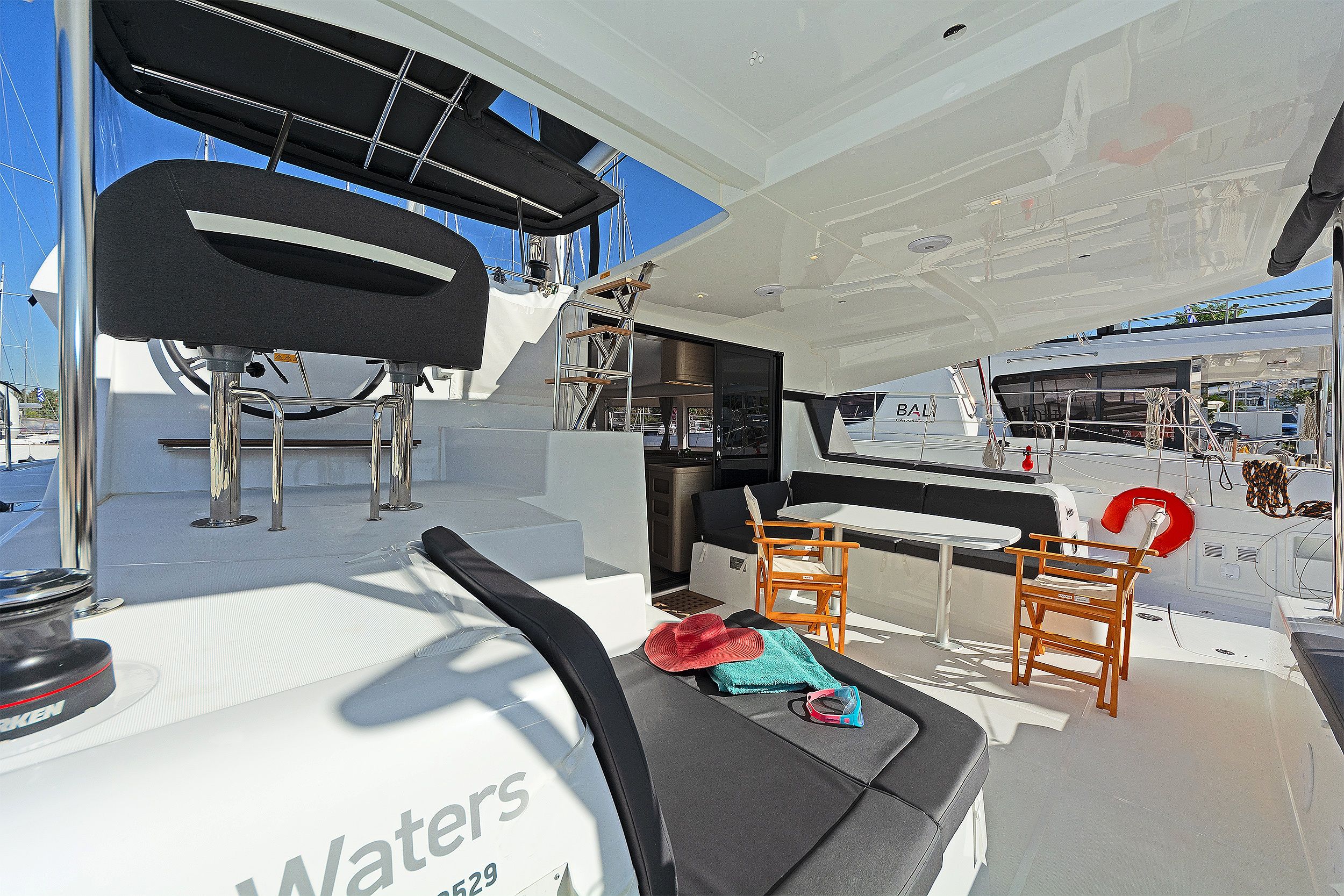 A boat's interior with a seating area, a table, and a lifebuoy.