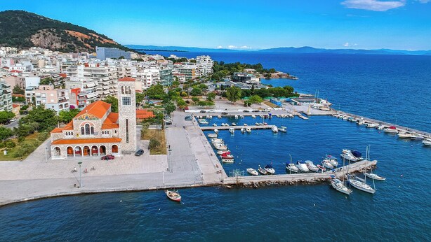 A coastal town with a prominent church, marina, and residential buildings.