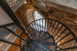 A spiral staircase with metal railings and a stone wall. - Greystead Old Church, Bellingham (Hexham)