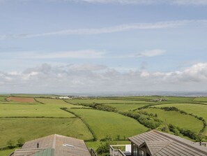 A rural landscape with rolling green fields and a distant town. - Three Views Lodge, Whitsand Bay (Torpoint)