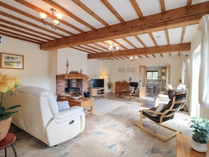 A spacious living area with a fireplace, comfortable seating, and a television.