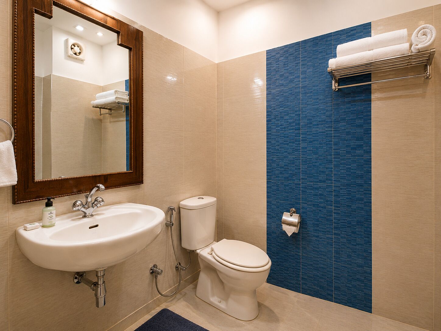 A bathroom with a sink, toilet, and a mirror.