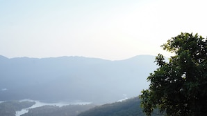 A balcony with a view of a lake and mountains. - Shelar Agro Tourism and Holiday Homes (Mahabaleshwar)