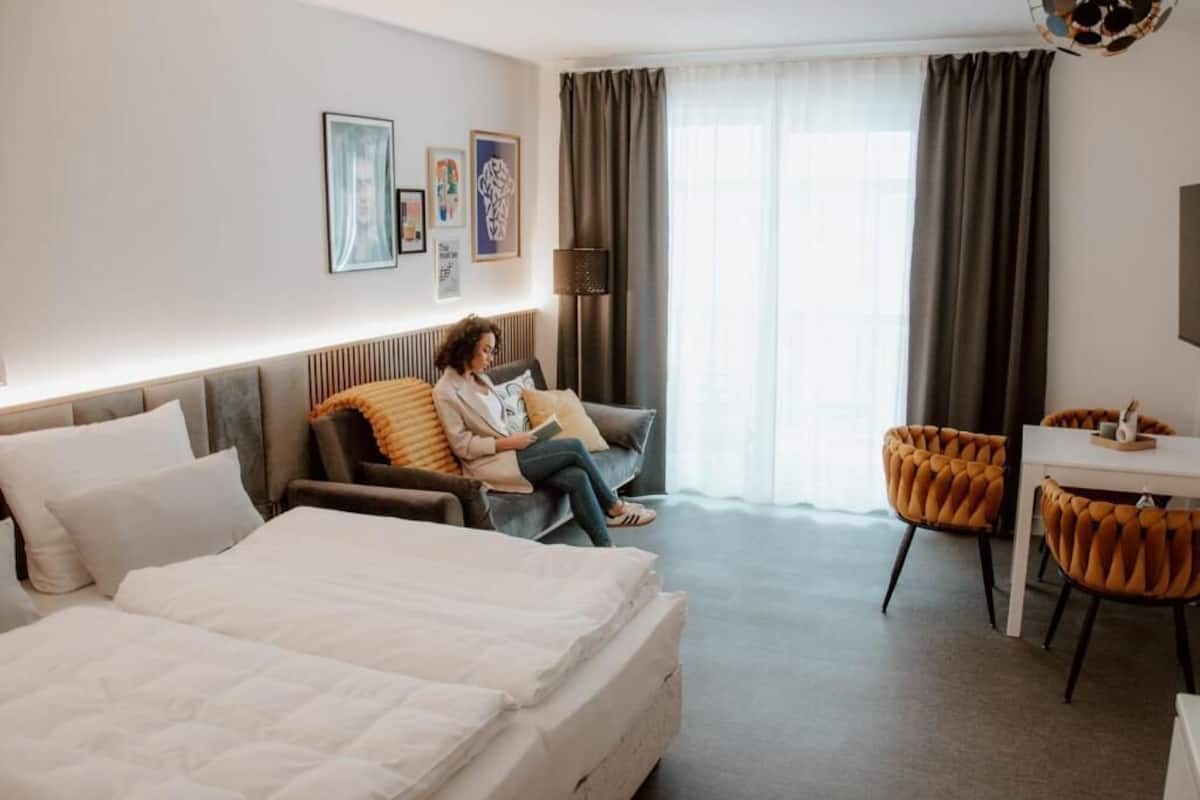 Habitación de hotel con cama, sofá, escritorio y una silla.