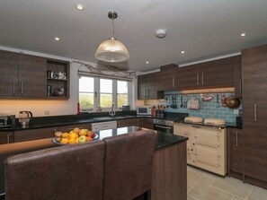 A modern kitchen with wooden cabinets, a central island, and a window providing natural light.