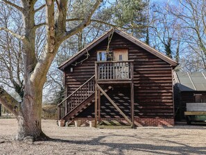 A rustic wooden cabin with a balcony, a staircase, and a small window. - Woodland Retreat Lodge, Laxfield (Woodbridge)