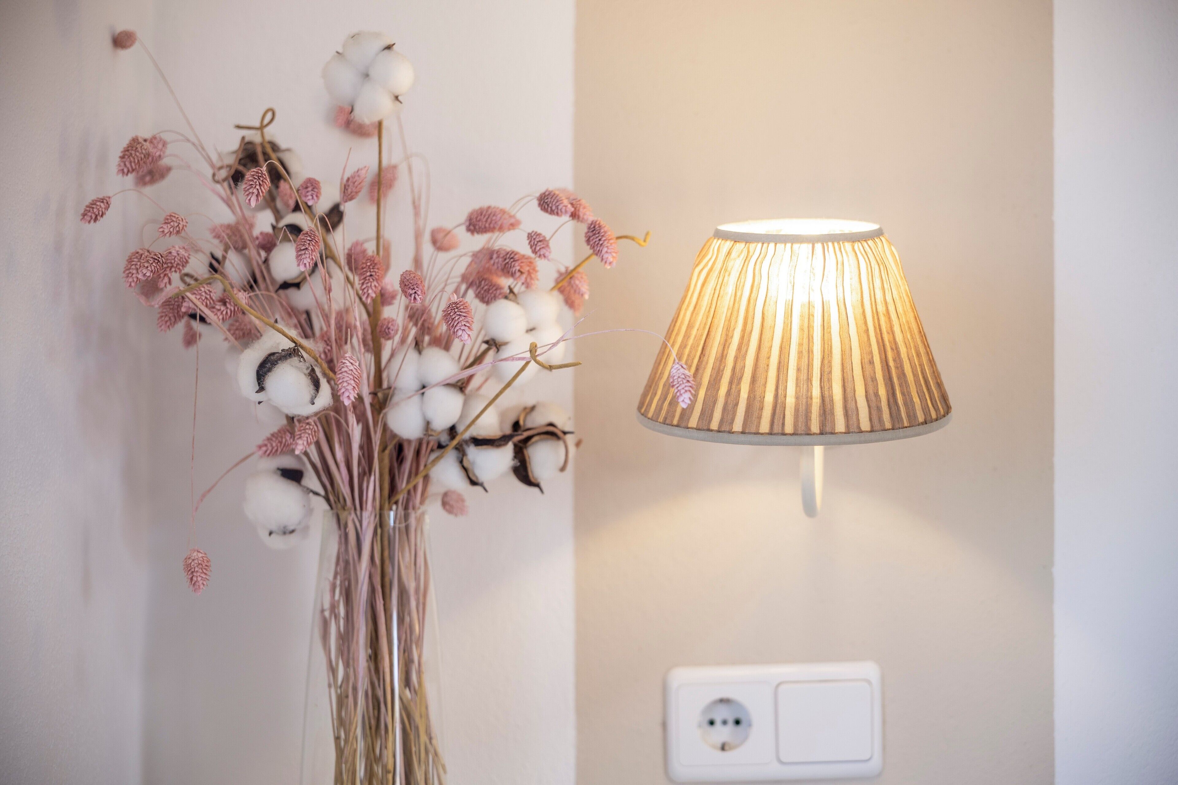 A wall-mounted lamp with a ribbed design and a switch below it.