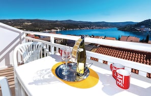 Ein Balkon mit einem Tisch für zwei Personen, einer Weinflasche und zwei Gläsern.