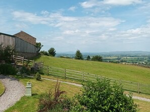 A rural landscape with a wooden barn, a gravel path, and a fenced area. - The Journeyman, Barnoldswick (Barnoldswick)