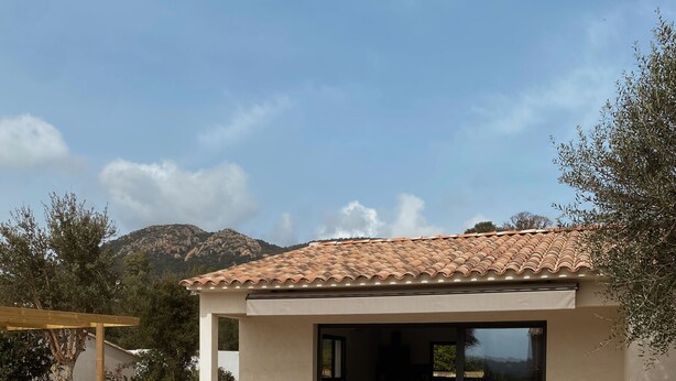 A modern house with a tiled roof, a patio with a table and chairs, and a view of the mountains. - Villa 6 persons with swimming pool and large garden near Porto-Vecchio (Zonza)