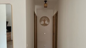 A hallway with a wooden floor, white walls, and a tree-shaped wall decoration. - Villa 6 persons with swimming pool and large garden near Porto-Vecchio (Zonza)