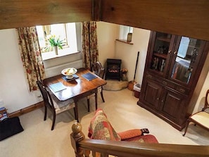 A dining area with a wooden table, chairs, a fireplace, and a cabinet.