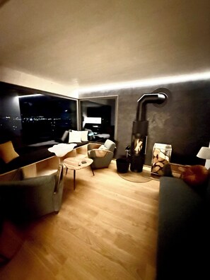 Un salon moderne comprenant un canapé, un fauteuil, une table basse et une cheminée.