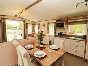 Interior acogedor de una caravana con comedor, cocina y zona de estar.