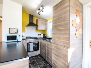 Una cocina moderna con microondas, estufa, horno y armarios de madera.