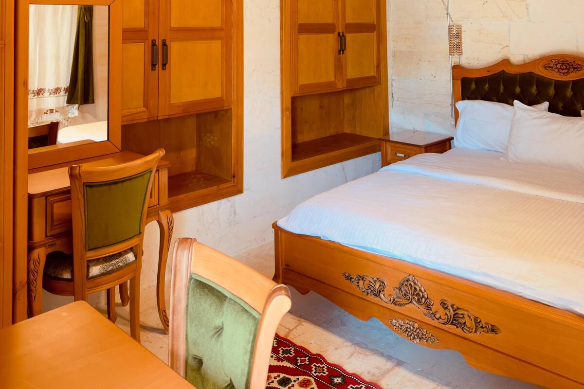 Un dormitorio con estructura de madera, una cama, un escritorio y una silla.