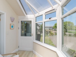 Una habitación con tragaluces, una puerta y ventanas amplias que ofrecen vistas al exterior.