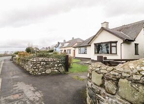 A row of houses with stone walls and a paved driveway.