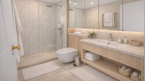 A modern bathroom with a glass shower enclosure, a toilet, a sink with a mirror above, and a vanity with storage. - Luxury Covent Garden Residence – 2 Bed 2 Bath (London)