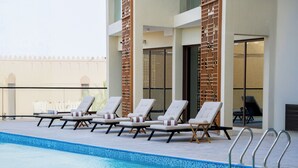A poolside area with lounge chairs and a swimming pool.