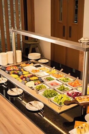 A buffet with various food options and utensils.