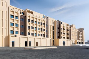 A modern hotel with a symmetrical facade, multiple balconies, and a central courtyard. - Tulip Residences Muscat The Village (Seeb)