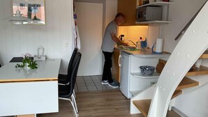 Eine kleine Küche mit Essbereich, Mikrowelle und Spüle.