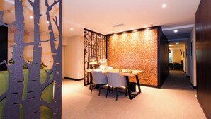 A modern dining area with a wooden table and chairs, a decorative wall, and a partition with tree cutouts. - OMID Boutique (Lisbon)