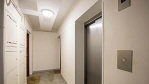 En hall med en dörr, en vägglampa och en dörrmatta.