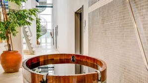 A wooden hot tub in a hallway with a tiled wall, a potted plant, and a staircase in the background. - 4 Star Holiday Home in Romo (Rømø)