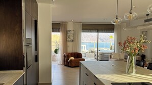 Una cocina moderna con una isla grande, armarios de madera oscura y vistas a un paisaje montañoso.