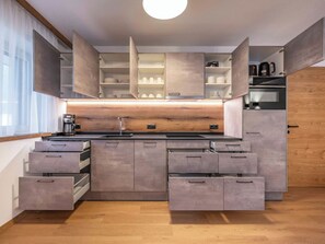 A modern kitchen with built-in cabinets, a central island, and a coffee machine. - Nice apartment for 5 people with WIFI, TV and balcony (Zell Am Ziller)