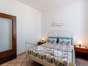 A bedroom with a bed, two bedside tables, a wall decoration, and a door. - Lovely apartment for 4 people with WIFI (Albenga)